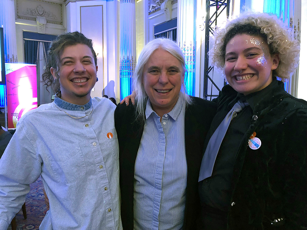 Julian and Alex from p10 pose on either side of Quebec Solidaire Leader Manon Masse